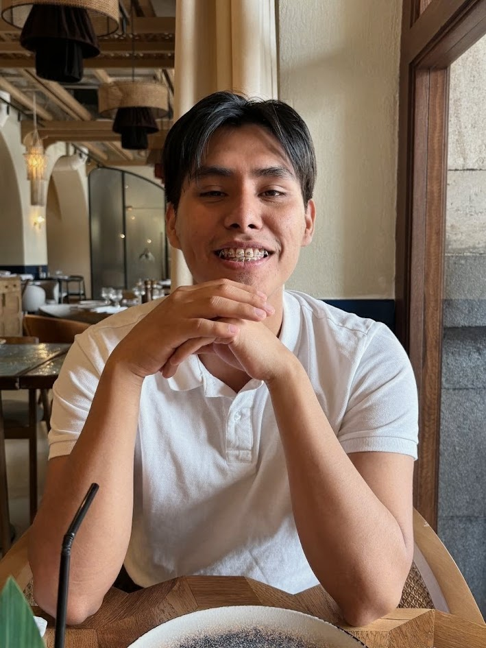 Luis Morón sonriendo, sentado junto a una ventana en un restaurante